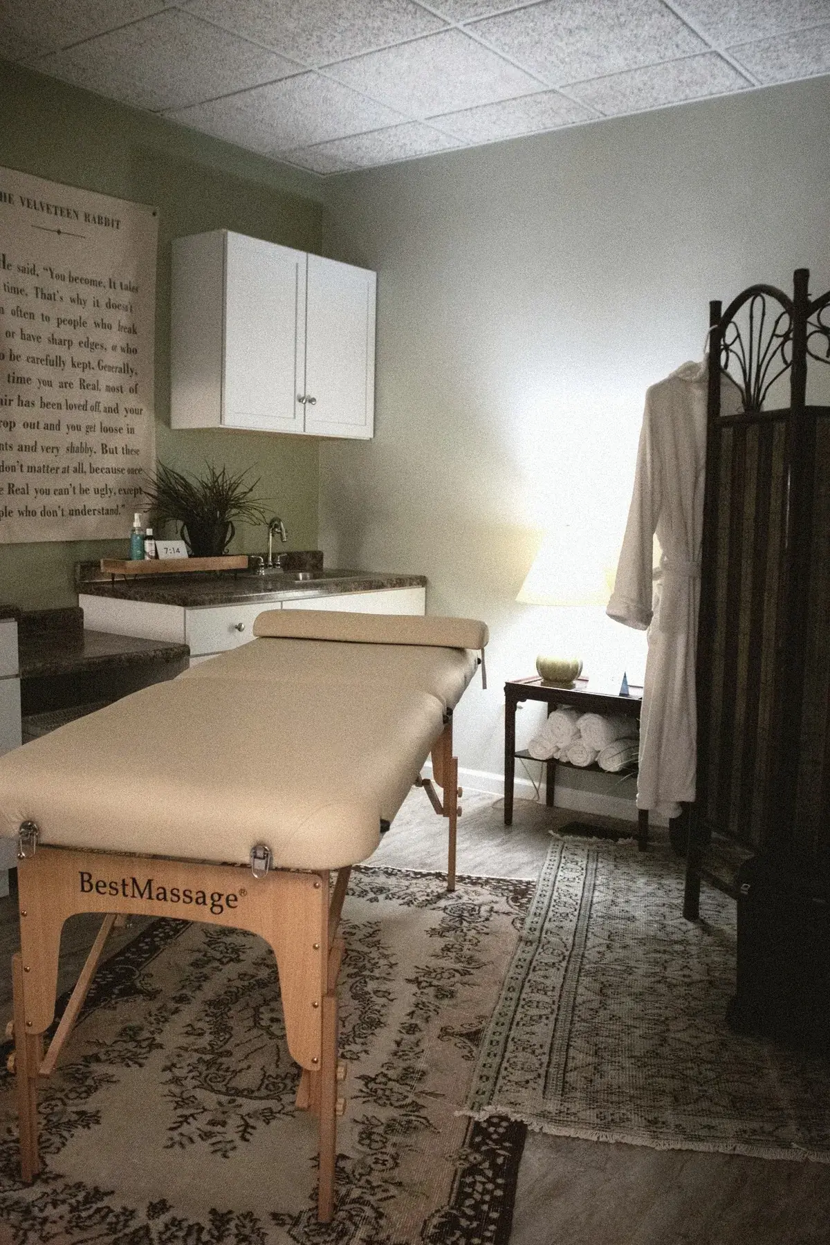 Spa treatment room with massage table and robe