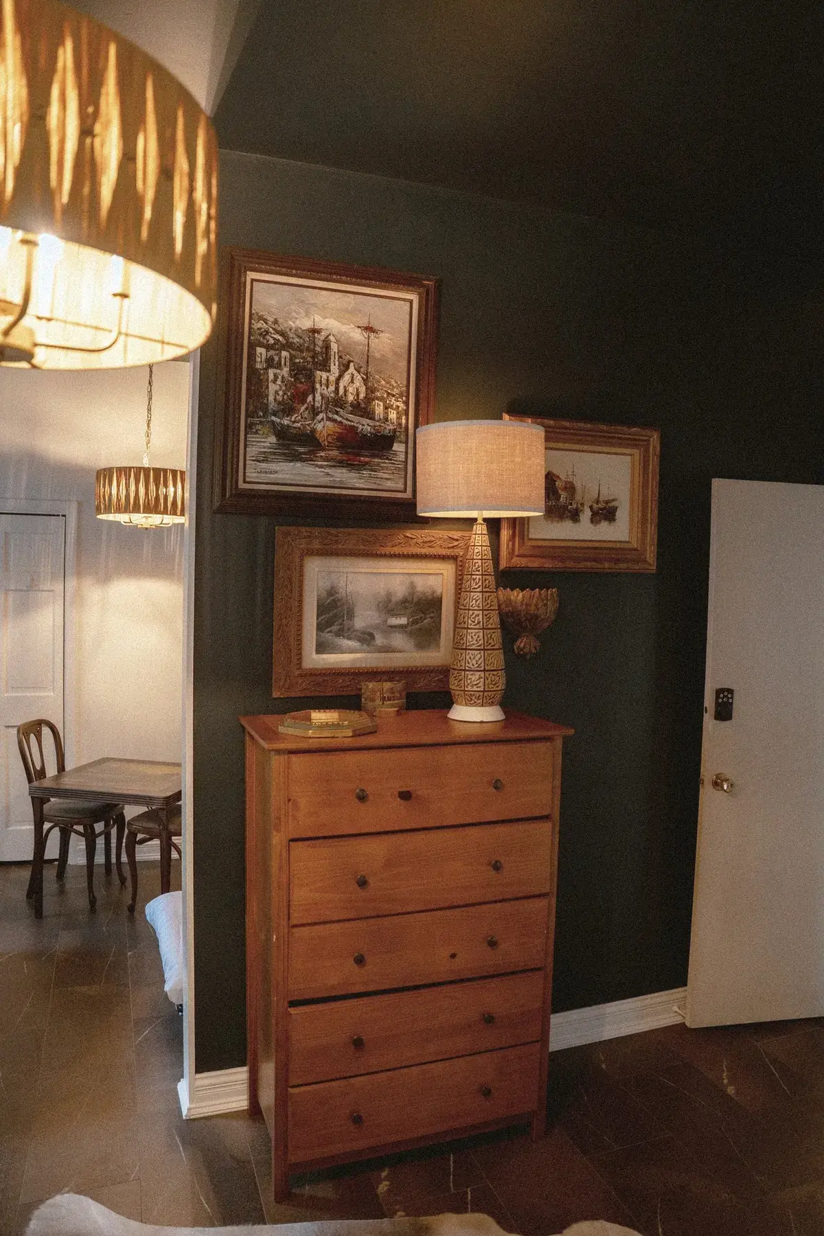 Dark wall with artwork and dresser vignette