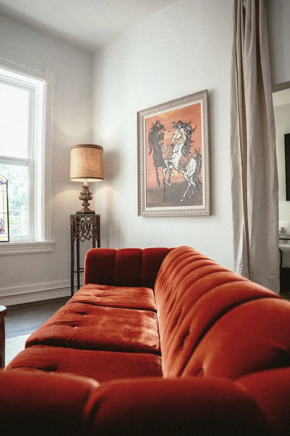 Red velvet sofa with equestrian art and stained glass