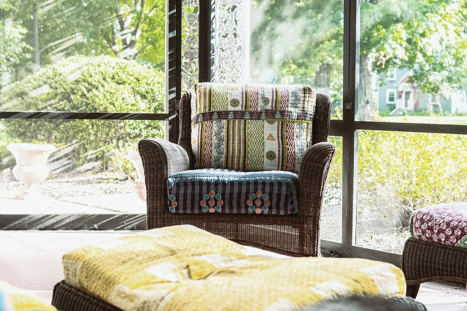 Screened porch with wicker chairs and colorful textiles