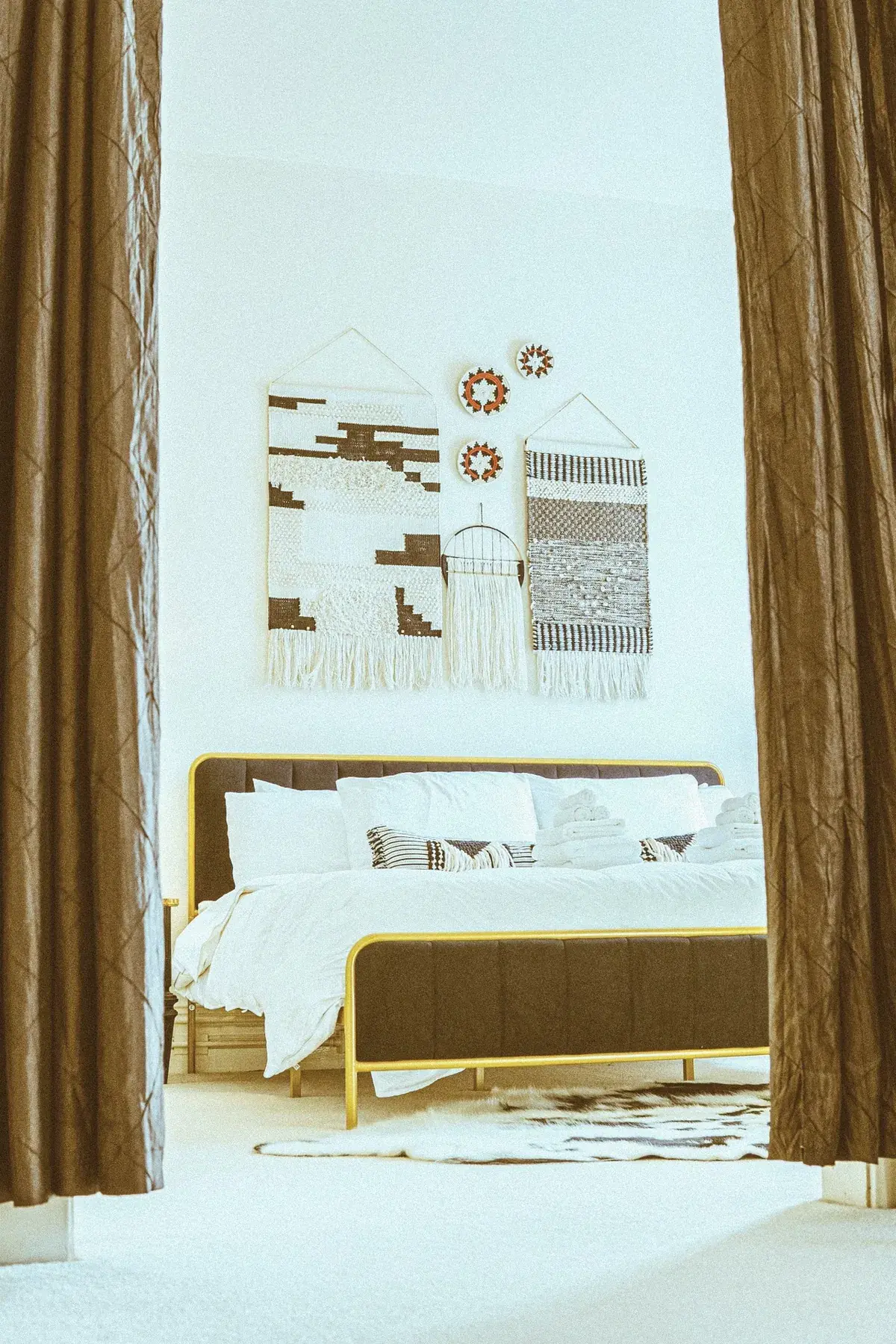 Modern bed framed by drapery with tall walls