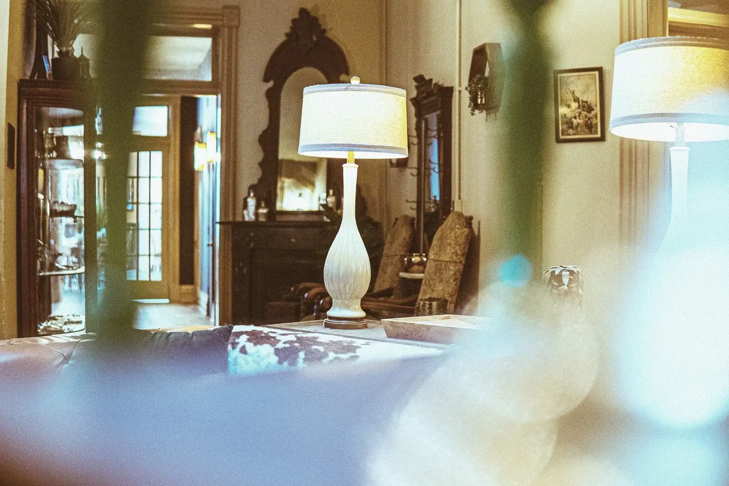 Lamps glowing across layered lounge with long sightlines